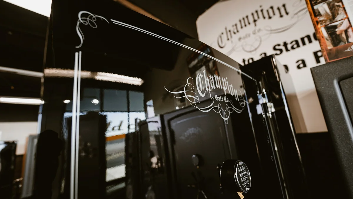 Close-up of a glossy black Champion safe door, logo and electronic lock